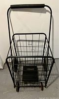Front view of black metal wire folding grocery cart showing basket and padded handle.