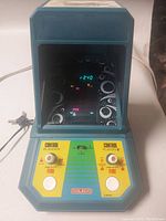 Front view of the Coleco Galaxian arcade game powered on with gameplay screen showing scores and alien formations.