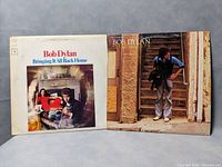 Front covers of two Bob Dylan vinyl records: "Bringing It All Back Home" and "Street-Legal" shown side by side.