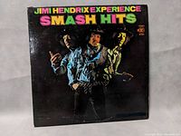 Front cover of Jimi Hendrix Experience Smash Hits vinyl album, showing band members and colorful title.