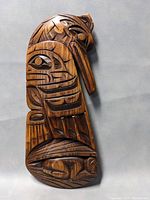 Overall view of the wooden raven claw carving showing full length and detailed carving patterns.