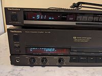 Side by side front view of Technics SU-V98 stereo integrated amplifier and ST-S98A AM/FM stereo tuner showing power switches, digital displays, and control knobs.