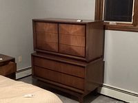 Straight-on front view of two-piece stacked dresser showing eight drawers and walnut veneer finish