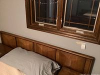 Full front view of headboard mounted behind mattress under window