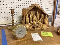 Photo showing olive wood nativity set with manger, figurines visible including baby Jesus in the manger, star on the stable, and two polished brass candlesticks, one showing Baldwin mark.