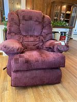 Front view of the plush burgundy fabric recliner chair with thick padding on the seat, back and armrests.