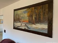 Front view of signed framed acrylic painting showing winter landscape with creek and sunset.