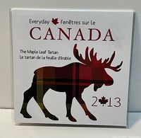 Original packaging showing a moose with a red and black plaid maple leaf tartan design and bilingual text referencing Canada 2013 Maple Leaf Tartan.