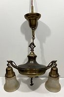 Full view of the Victorian brass chandelier hanging from ceiling mount showing two shades and decorative pan body.