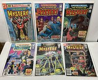 Six DC The House of Mystery comic books spread out, showing full front covers with colorful and horror-themed artwork.