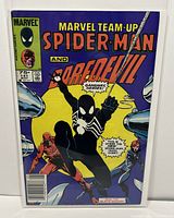 Front cover showing Spider-Man in black suit, Daredevil, and Black Widow with purple background and yellow circle behind Spider-Man