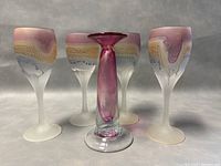 Four frosted glass wine goblets and the S. Bisley signed bottle, front view showing glass details and colors