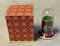 Toothpick holder with plastic dome and decorative box, all shown together.