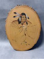 Front view of oval natural pine wood slab with Native American chief and eagle etching, signature front lower left.