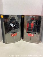 Two boxed Cruella De Vil collector dolls standing side by side, fully visible through clear front packaging windows.