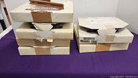 Six stacked original boxes containing Knowles collector plates, some boxes taped and labeled 'Grandpa's Treasure Chest'
