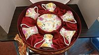 Full set of 6 cups and saucers in round box with red satin lining