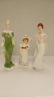 Three Royal Doulton vintage porcelain figures displayed side by side: Linda, Lori, and Lorna.