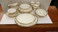 Full 38-piece Royal Doulton Forsyth fine bone china set with various plates, cups, bowls, gravy boat, serving dish and tray arranged on table.