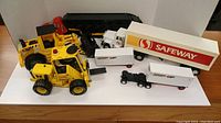 All five toy vehicles displayed together on white background including construction loader and Safeway trucks