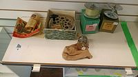 Photo of four vintage fishing reels displayed on shelf with original boxes and some fishing accessories and packaging.