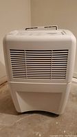 Front view of white Whirlpool Gold dehumidifier showing vents and base.