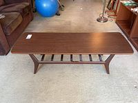 Full front view showing tabletop and slatted shelf