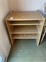 Front angle view showing wood veneer shelf unit with two pull-out sliding shelves and two fixed shelves below.