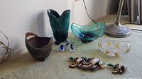 Overview photo showing all items in lot including pottery vase, art glass bowls, crystal bowl, and glass figurines.
