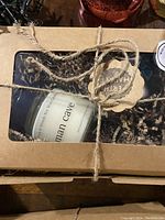 Gift set in brown cardboard box with candle labeled 'man cave' and Epsom salts, tied with rustic twine and Erin Market tag.