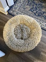Top-down view of a large round dog bed showing its fluffy texture and circular raised edges.