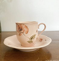 Side view of a Mikasa Oriental Poppy teacup resting on a matching saucer, showing floral design and cup shape.
