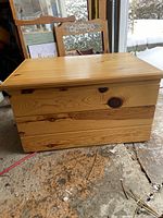 Pine blanket box showing natural wood finish, visible grain and knots, lid closed.