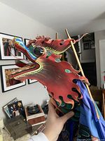 Close up of the red dragon head of the kite with painted details and large eyes.