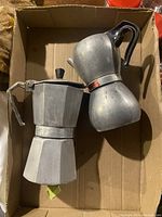 Photo of two vintage Italian moka pots in a cardboard box, showing wear and needing repair.