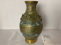 Front view of brass cloisonné vase showing pattern, ring handles and shape.
