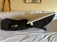 Full view of Cowboy Studio softbox with attached light fixture and black carrying bag on a bed.