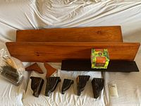 Two pine shelves, five vintage carved wood corbels, two wood screw-in legs and a boxed tree planting kit, all displayed on a fabric surface for scale and condition checks.