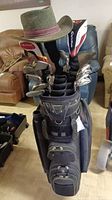 Full view of Knight golf bag loaded with clubs and men’s hat on top