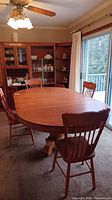 Dining table extended with four leaves installed and four matching chairs