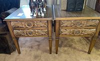 Pair of mid-century Lane end tables with carved drawer fronts and floral circular motifs on drawer pulls.