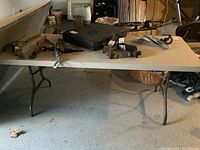 Full view of the 6ft Lifetime foldable table with various items placed on top, showing table surface and folded metal legs.