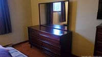 Front view of dresser with mirror attached showing six drawers and wood finish