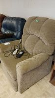 Front and side angled view of beige power lift recliner chair with wired remote and power cord on seat.
