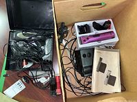 Purple WAHL cordless clipper with charger base, clipper guards, multiple wires, and user manual inside a cardboard box.