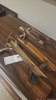 Two pairs of antique wooden skates with metal blades and leather straps laid on a wooden surface.
