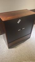 Front and side view of the Mid-Century Modern style wood cabinet with black doors