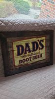 View of the front of the wooden sign showing the Dad's Old Fashioned Root Beer design and overall size and condition.