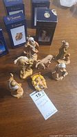 Image showing eight nativity figurines arranged on a table with blue Fontanini boxes behind them.