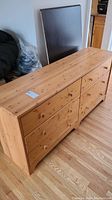 Side angle view of the full pine dresser showing multiple drawers with round wooden knobs and natural pine wood texture.